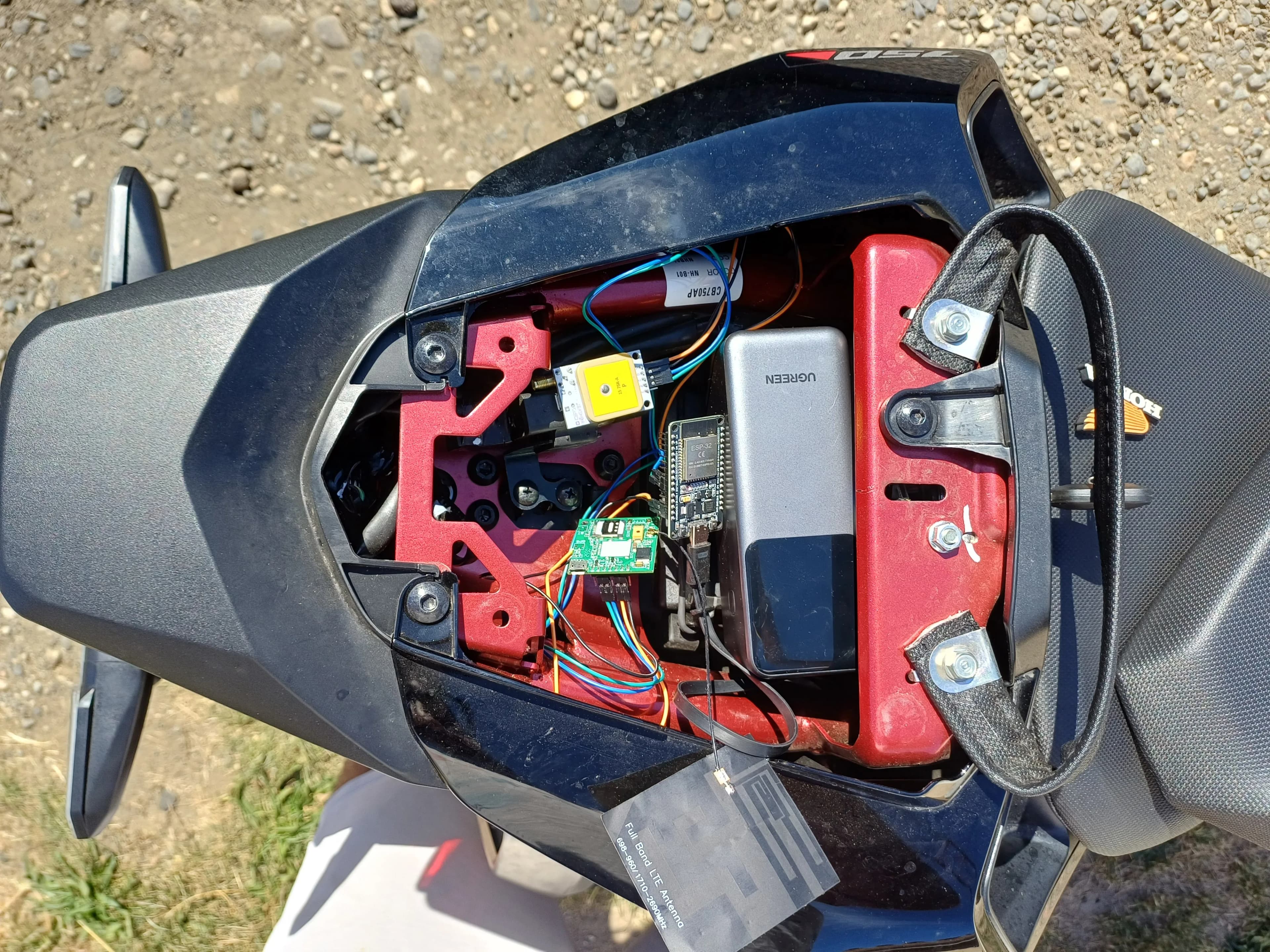 Le coffre de la moto ouvert, avec le tracker à bord.